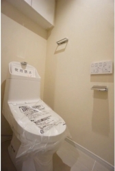 　温水洗浄機能付きトイレ。吊戸棚があり収納に便利です。