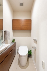　スタイリッシュなタンクレストイレ。吊戸棚にはトイレットペーパーや掃除用具を収納できるので便利です。
