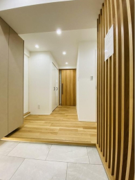 　石張り調の玄関タイルは、清潔感と明るさを演出し、木のパーテーションにより空間を分けております。